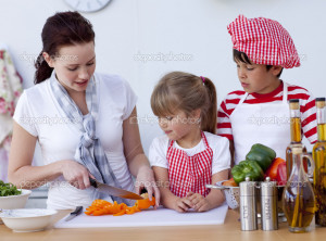 Children helping mother cooking in the kitchen - Stock Image