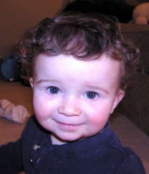 picture of a funny cute baby with a smile on his face posing for a cam