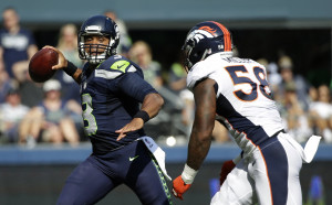 quarterback Russell Wilson passes under pressure from Denver Broncos ...