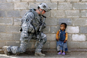 An Iraqi boy looks up a US soldier