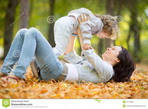 Happy family having fun outdoors in autumn park against blurred leaves ...