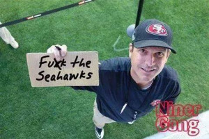 coach Jim Harbaugh as he smiles while posting up this sign Hilarious