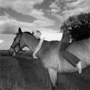 Black and White of a Girl Laying on a Horse