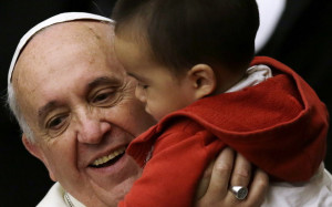Pope Francis holds a baby as he meets children at the Vatican last ...