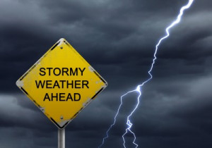 Stormy weather ahead sign with lightning bolt beside it.