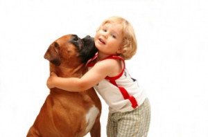 little girl gives her dog a hug.