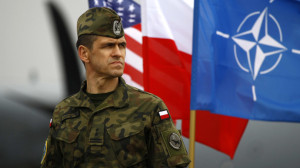 Polish soldier stands near U.S. and Poland's national flags and a NATO ...