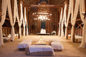 The dance floor, white drapery, and hay bale seating inside the barn ...
