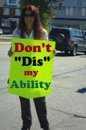 Woman holding a sign reading, 'Don't 'Dis' My Ability!'