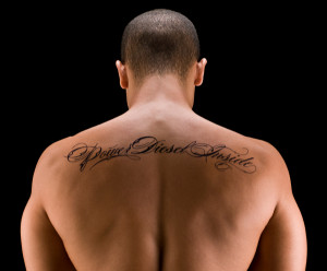 Quote tattoo design on upper back for men – back tattoo idea for men