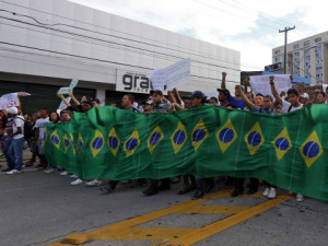 /Marcos Brindicci Demonstrators carry a banner made of Brazilian ...