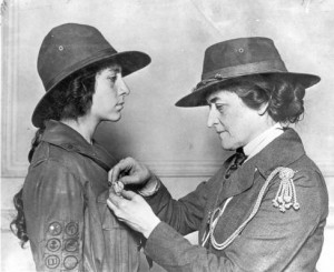 Juliette Gordon Low pinning a badge on a Girl Scout circa World War I.