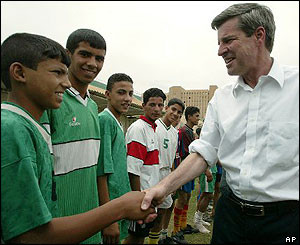 Paul Bremer shakes hands with members of a boys 39 football team soon