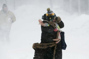... holds onto her hat against the wind during a snow storm in Boston