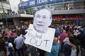 holds a photo cutout of Los Angeles Clippers owner Donald Sterling ...