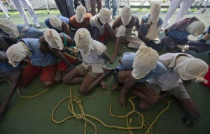 Suspected Somali pirates sit with their faces covered with cloth sacks ...