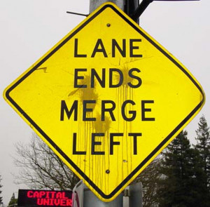 Photograph of a lane ends merge left sign
