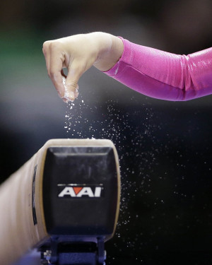Nastia Liukin sprinkles chalk on the balance beam at the gymnastics ...