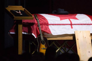 Stompin' Tom's hat, guitar and stomping board lie against his casket ...