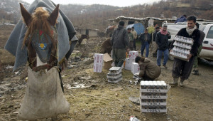 Smugglers along the Iran-Iraq border carry cases of liquor and beer ...