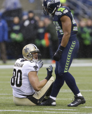 New Orleans Saints tight end Jimmy Graham, left, sits on the ground ...