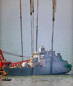 The bow of the sunken South Korean naval vessel Cheonan is lifted by a ...