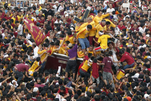 Devotees clamber onto a carriage to touch the statue of the Black ...