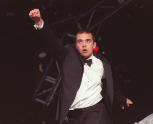 Robbie Williams punches the air on stage during the V Festival 1998