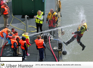 Kids playing with a water hose during coast guard demonstration.