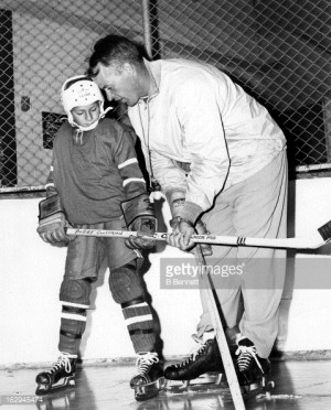 Gordie Howe shows ten year old Bobby Geoffrion how to hold a ...