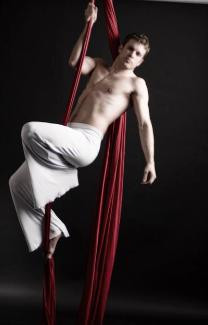 Aerial Silks solo performer in white costume with red silk