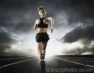 Woman running on road under stormy sky