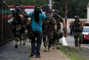 pedestrian is confronted by riot police. Ferguson, Missouri, Aug. 11 ...