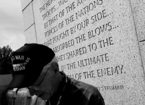 World War II veteran Lee Gallaher stands near a quote from President ...