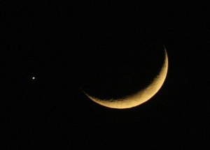crescent moon is seen with the planet Jupiter in the sky over Amman ...