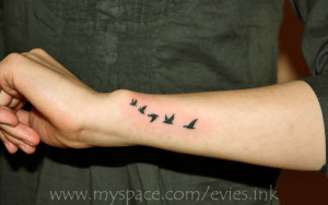woman's outer forearm and wrist--flying birds tattoo