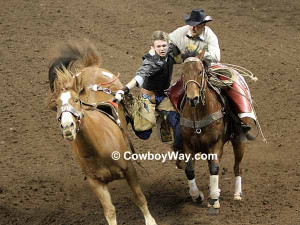 young bareback bronc rider has trouble getting off his bronc