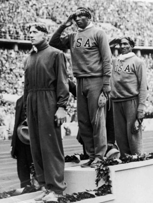 Jesse Owens stands on the podium after winning the gold medal in the ...