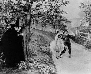 Margaret Hamilton, as The Wicked Witch of the West, hides behind a ...