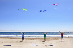 Three people flying kites at the beach - Geri Lavrov/Photographer's ...