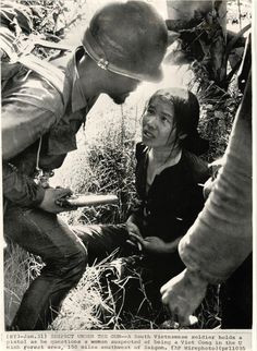 SUSPECT UNDER THE GUN - A South Vietnamese soldier holds a pistol as ...