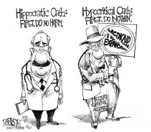 ... nothin'. A man holds a sign with Medicaid Expansion crossed out on it