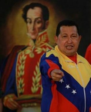 Venezuelan President Hugo Chávez in front of a painting of Simón ...