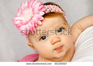 ... : Adorable baby girl with bright eyes posing with a pink flower band