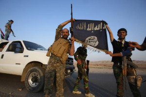 Iraqi Shiite militia fighters hold the Islamic State flag as they ...