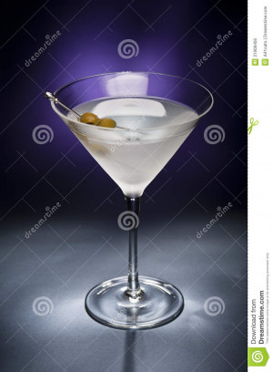 Vodka Martini with olive garnish in front of a black blue background ...