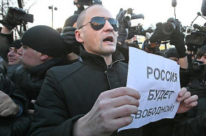 Sergei Udaltsov an opposition leader holds a paper with a sign
