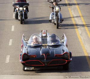 evel knievel in passenger seat rides in the batmobile leading the evel