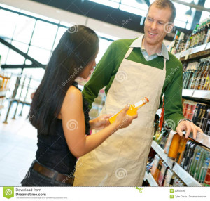 ... with smiling store worker while holding drink bottle in grocery store