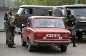 Pro-Russian rebels inspect a car at a checkpoint near a Ukrainian ...